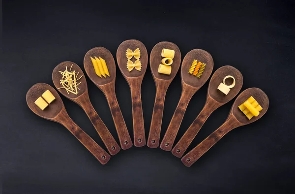Wooden Cooking Spoons Filled Various Types Dry Pasta Isolated Black — ストック写真