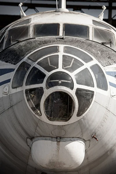 an old plane on the ground, in an old hangar