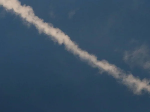 Trilha branca de um avião no céu azul — Fotografia de Stock