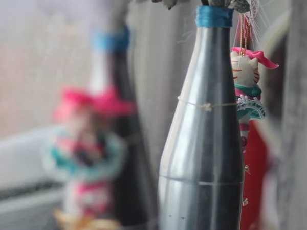 Weihnachtlicher Spielzeugtiger mit einer Flasche, die an einer Fichtenpfote hängt — Stockfoto