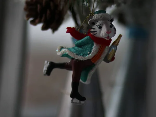 Christmas toy tiger with a bottle hanging on a spruce paw — Stock Photo, Image