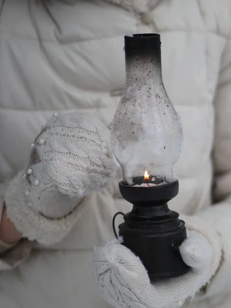Ręce w rękawiczkach posiadają zapaloną antyczną lampę — Zdjęcie stockowe