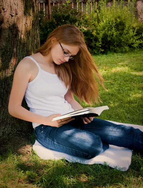 Adolescente chica leyendo en patio — Foto de Stock