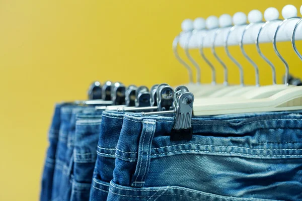 Row of hanged blue jeans in a shop — Stock Photo, Image