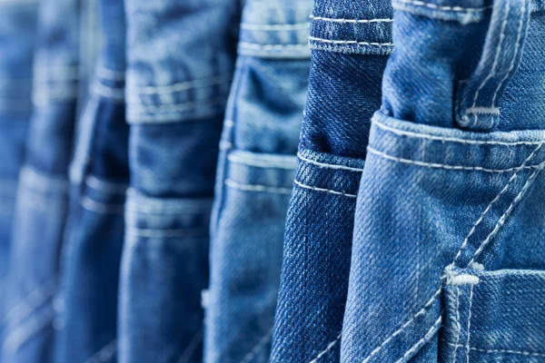 Fila de jeans azuis enforcados em uma loja — Fotografia de Stock