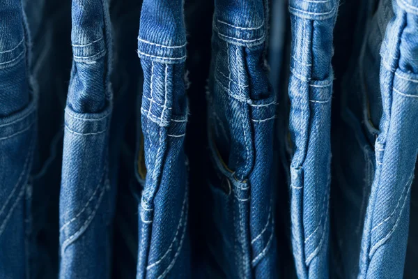 Row of hanged blue jeans in a shop — Stock Photo, Image