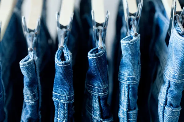 Row of hanged blue jeans — Stock Photo, Image