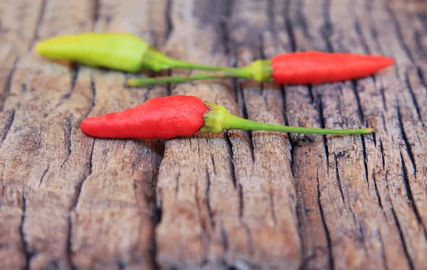 Hot chili pepper on old wooden background — Stock Photo, Image