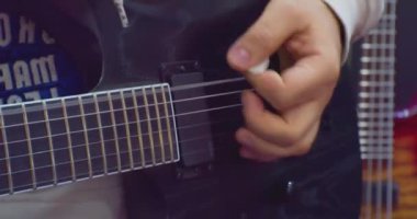 Tanınmayan bir adam elektro gitar çalıyor. Yakın plan.