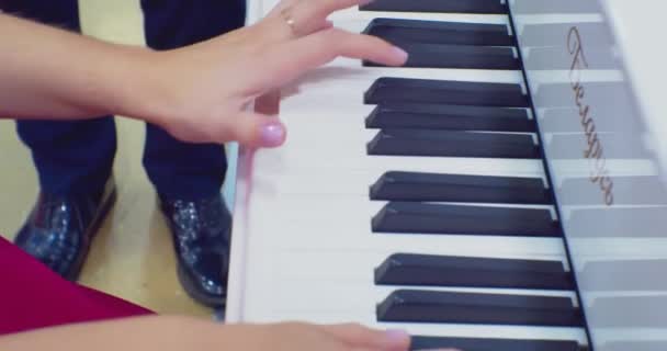 Γυναικεία χέρια παίζουν πιάνο. Η γυναίκα αγγίζει τα δάχτυλα των κλειδιών. Κλείσε. — Αρχείο Βίντεο