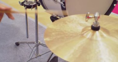 Davulcu sahnede davul çalıyor. Davul sopaları cymballara çarpıyor. Yakın plan.