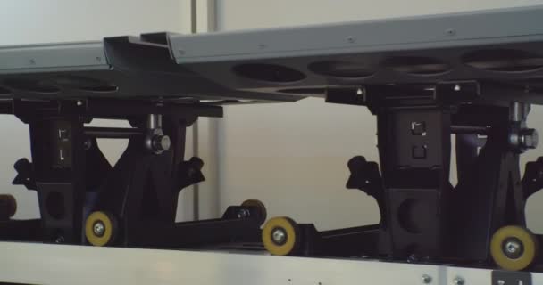 Modern peralatan gudang kereta api dari roller conveyor gerobak bergerak pada rel di dalam gudang .close-up — Stok Video