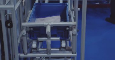 Modern depo ekipmanları. Plastik konteynır taşıyıcı boyunca hareket ediyor. Yakın plan.