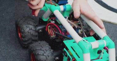 Tornavida kullanarak ev yapımı bir robotu tamir etmek. Çalışan bir adamın elleri. Yakından.