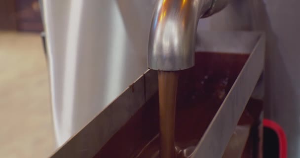 Equipos modernos para la producción industrial de alimentos.chocolate fundido en caliente se vierte desde un recipiente de metal a través de un tap.close-up — Vídeo de stock