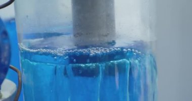 Modern teknoloji. Pompa donanımı. Güzelce aydınlatılmış sıvı şeffaf bir cam tüpe pompalanır. Yakın plan.