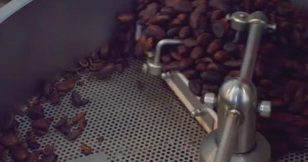 Endüstriyel gıda üretimi. Modern kızartma makinesinde koyu ve aromatik kahve çekirdekleri. Yakın çekim. — Stok video