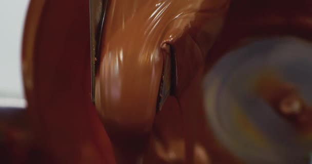 Produção de alimentos industriais.Fabricação de chocolates.Chocolate líquido quente em uma máquina de têmpera de chocolate. — Vídeo de Stock