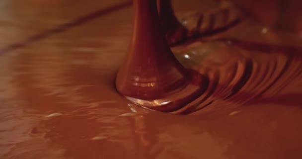 Produção industrial de alimentos. um fluxo de chocolate quente é derramado em uma panela grande. close-up do processo tecnológico — Vídeo de Stock