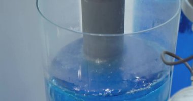 Modern endüstriyel ekipman. Su tedavisi. Güzelce aydınlatılmış sıvı şeffaf bir cam tüpe pompalanır. yakın plan