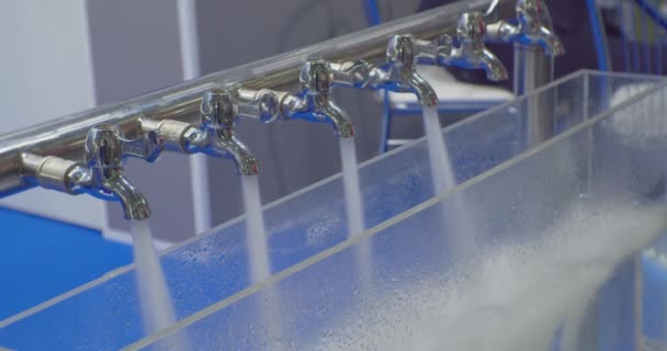Les technologies modernes. essais et démonstration du travail des équipements modernes de traitement de l'eau. jets d'eau propre sont versés à partir de plusieurs robinets de mélangeur de métal. — Video
