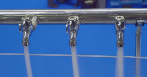Chorros de agua limpia se vierten de los grifos de metal de los mezcladores.Primer plano — Vídeos de Stock
