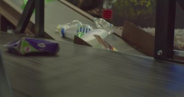 Atık ayıklama merkezi. Plastik ambalajın endüstriyel geri dönüşümü. Plastik şişeler daha ileri işlemler için taşıma bandında hızlı hareket eder. Yakın çekim.