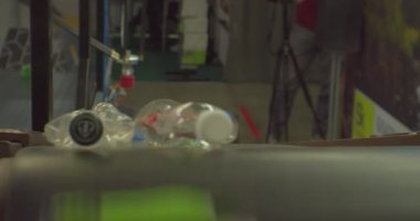 Modern atık tasnif merkezi. Plastik ambalaj endüstriyel işleme. Kullanılmış plastik şişeler daha ileri işlemler için taşıyıcı bant boyunca hızlı hareket eder. Yakın plan.