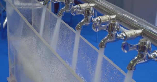 Tecnologías modernas. pruebas y demostración del trabajo de equipos modernos para el tratamiento del agua. chorros de agua limpia se vierten de varias cintas mezcladoras de metal.Close-up — Vídeos de Stock