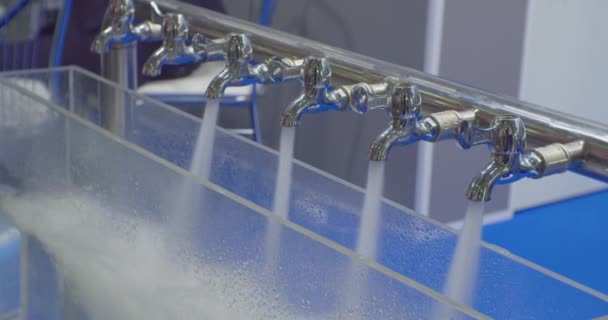 Сучасні технології. тестування та демонстрація роботи сучасного обладнання для очищення води. струмені чистої води заливаються з декількох металевих змішувачів. Закрити — стокове відео