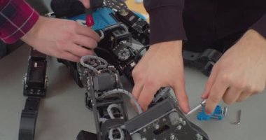 Bozuk robot tornavidayla birleştiriliyor. Çalışan bir adamın elleri. Yakından.