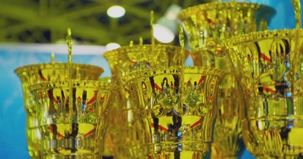 Realizações esportivas e awards.several copos de ouro idênticos estão na prateleira.close-up — Vídeo de Stock