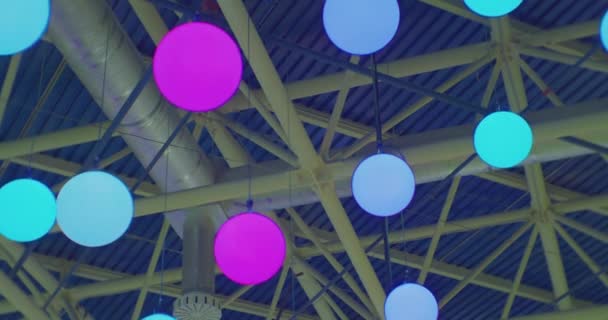 Багато яскравих лампочок, які рухаються синхронно під стелею.абстрактний святковий фон — стокове відео