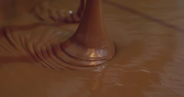 Produção industrial de alimentos. um fluxo de chocolate quente é derramado em uma panela grande. close-up do processo tecnológico — Vídeo de Stock
