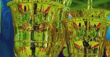 Spor geçmişi ya da ekran koruyucusu. Modern spor ödülleri. Rafta birbirinin aynı birkaç altın bardak var.