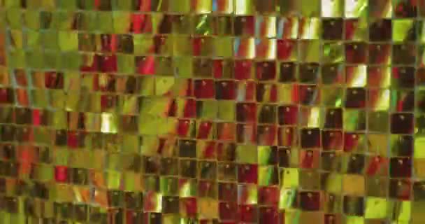 Muchas placas de oro pequeñas y brillantes brillan, reflejando la luz del sol. fondo festivo abstracto — Vídeos de Stock