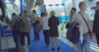 İş temasının arka planı bulanık. Büyük, parlak bir iş merkezinde tanınmayan insanlar.