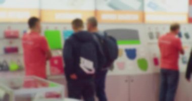 İş temasının arka planı bulanık. Büyük bir ofis merkezinde tanınmayan insanlar.