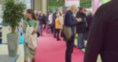 Modern iş hayatı. Odaklanamadığı bulanık video. Geniş bir salonda tanınmayan insanların bulanık siluetlerinin olduğu bir iş temasının arka planı.