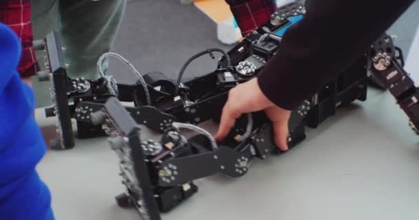 Menselijke handen zijn bezig met het repareren van een gebroken robot met een schroevendraaier.close-up — Stockvideo
