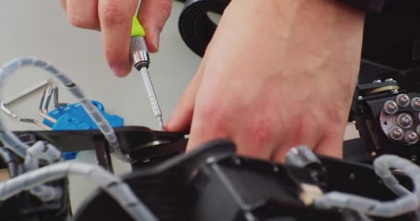 Montage van een complex mechanisme met een schroevendraaier.handen van een werkende man close-up — Stockvideo