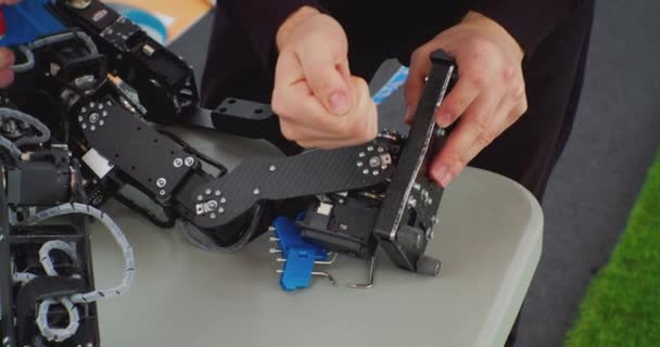 Mechanical assembly of the robot using a screwdriver. hands of a working man close up — Stock Video