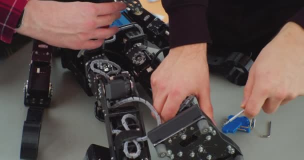 Montagem mecânica do robô usando uma chave de fenda. mãos de um homem de trabalho de perto — Vídeo de Stock