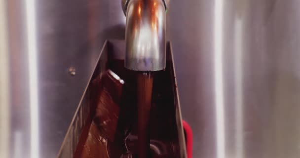 Moderne apparatuur voor industriële voedselproductie.een stroom van hete gesmolten chocolade giet uit de kraan. close-up — Stockvideo