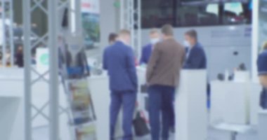 İş temasının arka planı bulanık. Büyük, parlak bir iş merkezinde tanınmayan insanlar.