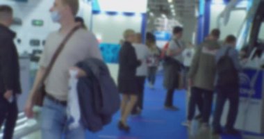 İş temasının arka planı bulanık. Büyük, parlak bir iş merkezinde tanınmayan insanlar.