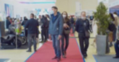 Modern iş hayatı. Odaklanamadığı bulanık video. Geniş bir salonda tanınmayan insanların bulanık siluetlerinin olduğu bir iş temasının arka planı.