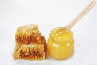 Beyaz arka planda bal petekleri içinde bal parçaları