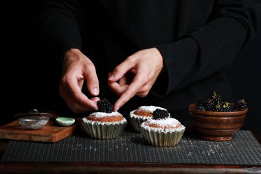 delicious cupcakes with blackberries and powdered sugar