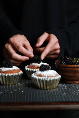 delicious cupcakes with blackberries and powdered sugar